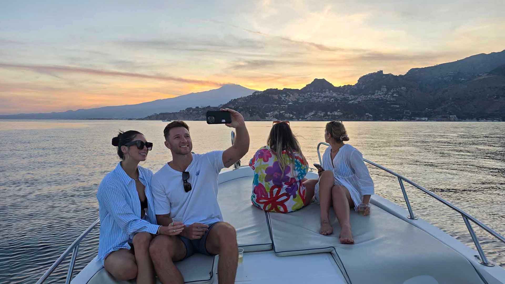 Tramonto dorato sul mare durante il tour in barca di gruppo a Taormina