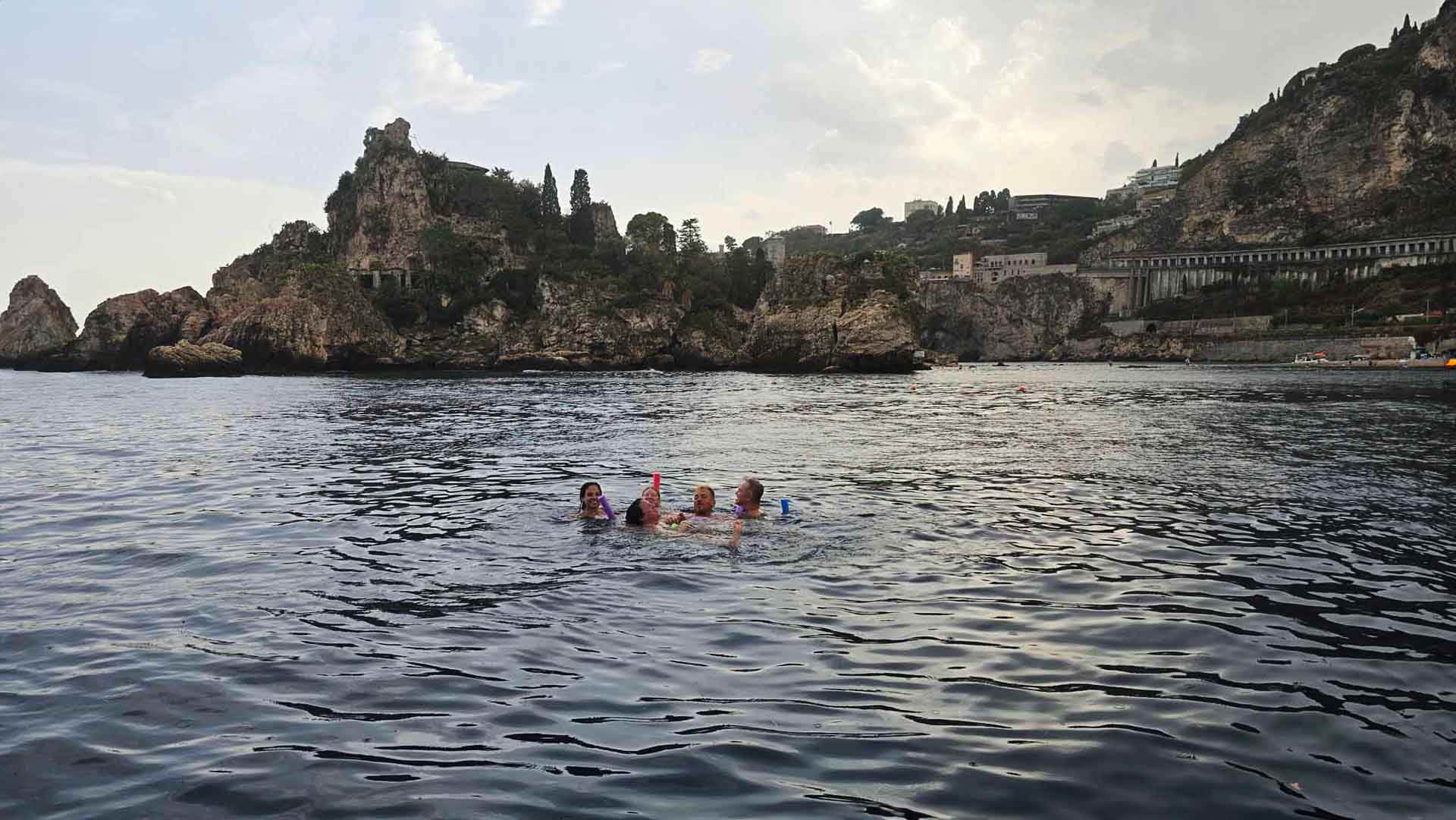 Baie e grotte di Taormina al crepuscolo viste dal mare