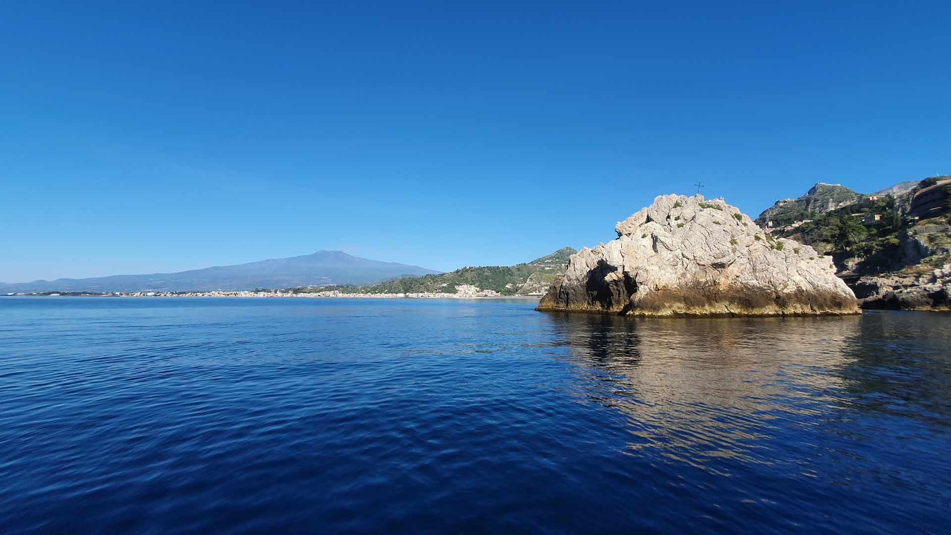 Boat sailing the Taormina coastline during the wine tasting tour