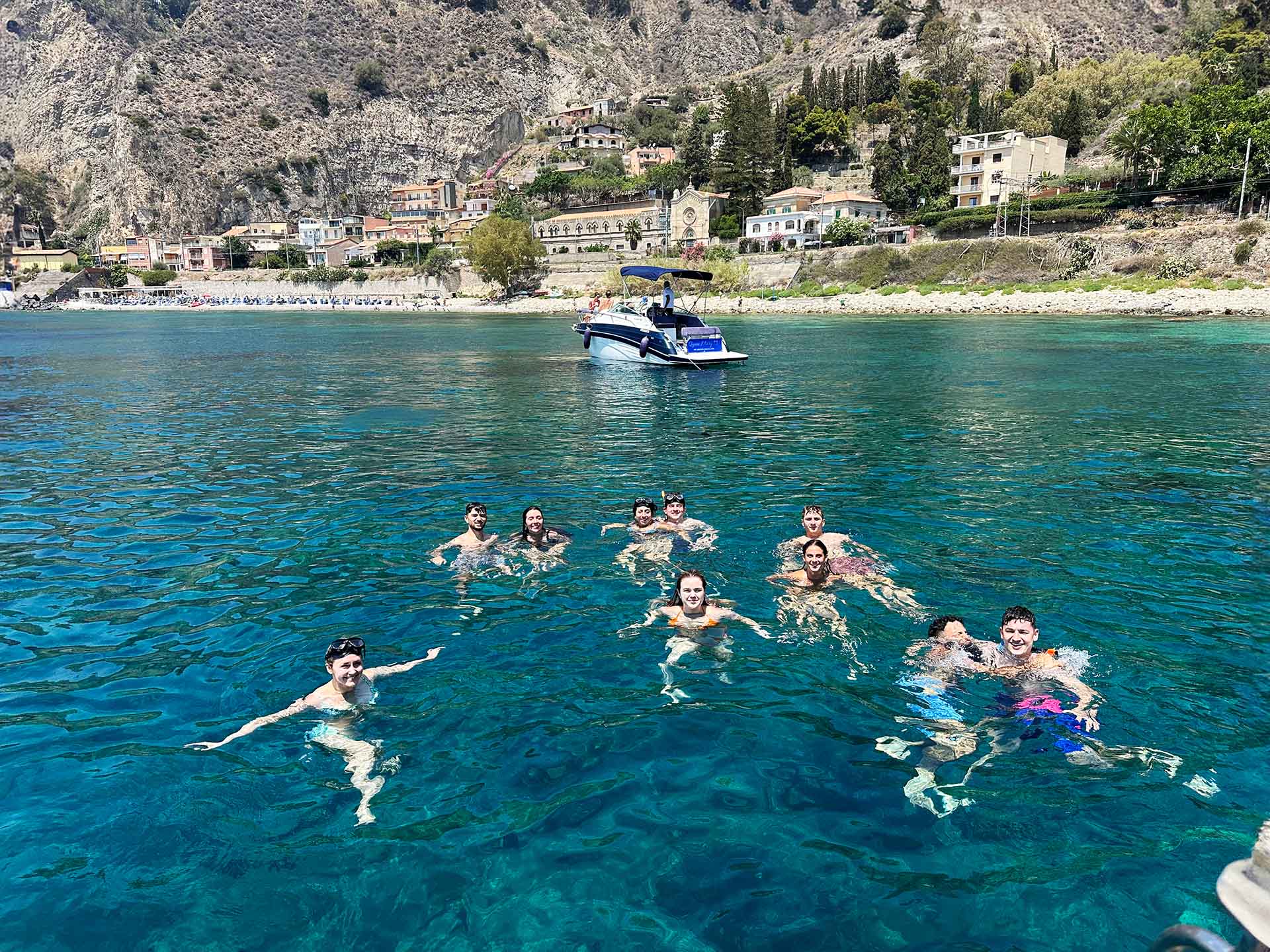 Swimmer diving from the boat on the Taormina snorkeling tour