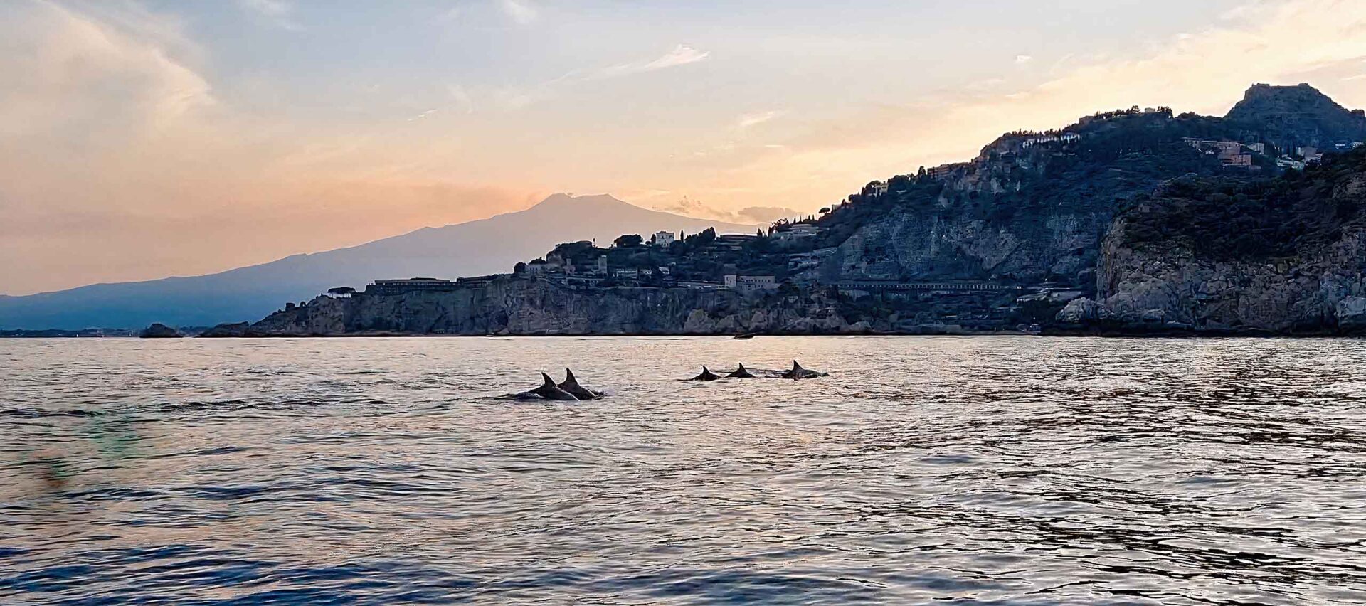 Cielo arancione e viola sul mare di Taormina al tramonto